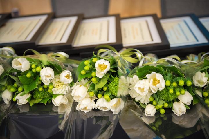 Chancellor Awards flower bouquets and certificates arranged on a table.